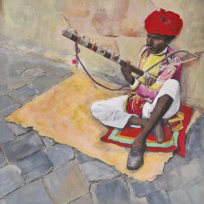 Shalini Bharadwaj, Desert Song Jaipur - a man sits on a rug against a stone wall. 